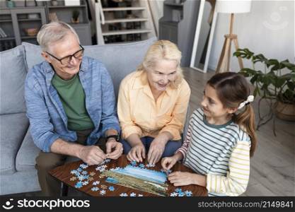 grandparents girl doing puzzle medium shot