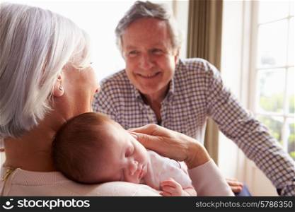 Grandparents Holding Sleeping Newborn Baby Granddaughter