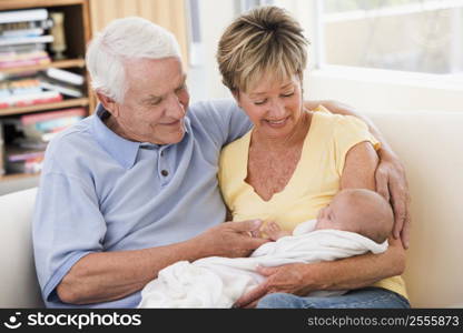 Grandparents in living room with baby smiling