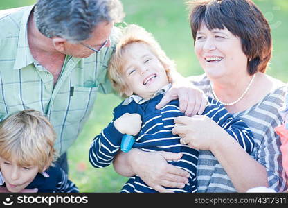 Grandparents tickling grandson