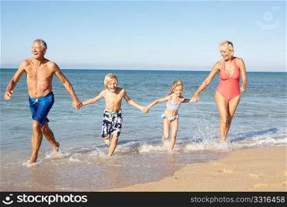 Grandparents With Grandchildren Enjoying Beach Holiday Together