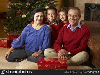 Grandparents With Grandchildren In Front Of Christmas Tree