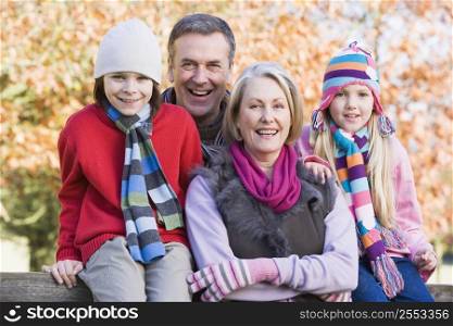 Grandparents with grandchildren outdoors in park smiling (selective focus)
