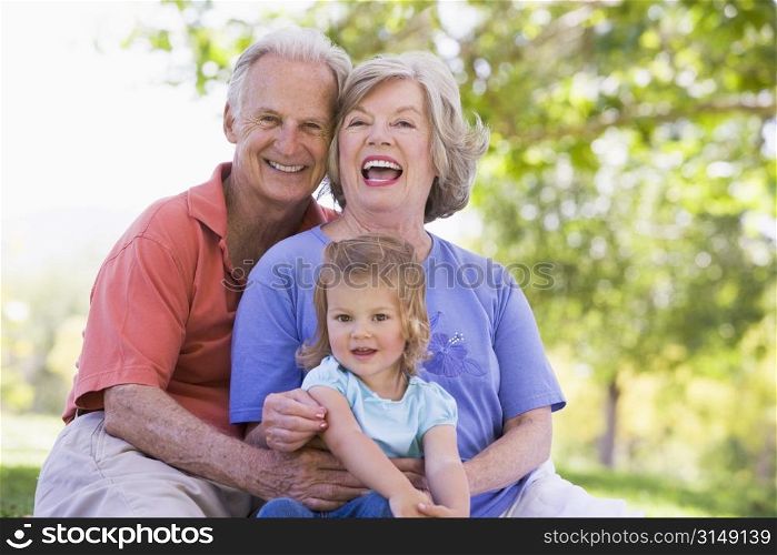 Grandparents with granddaughter in park