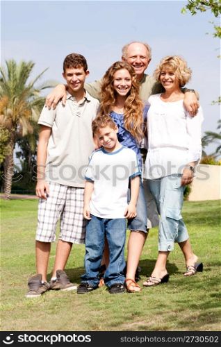 Grandparents with their children posing in the park, outdoors