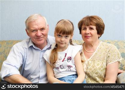 grandparents with their little daughter at home