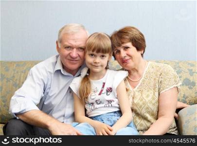 grandparents with their little daughter at home