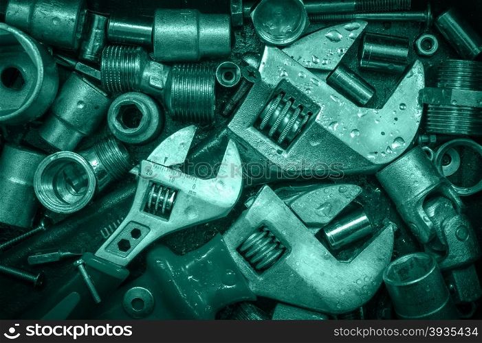 Grange background with wet tools and bolts. Adjustable wrenches, screws, nuts. Toned.