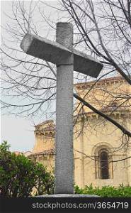 granite cross in front of a church