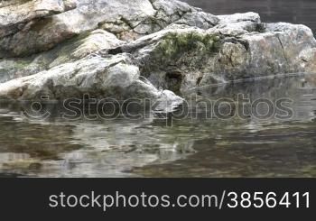 Granite stones in river waves.