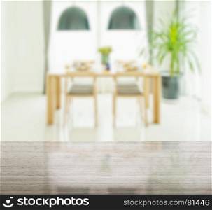 granite table top and blur of wooden dining table and chairs with elegant table setting