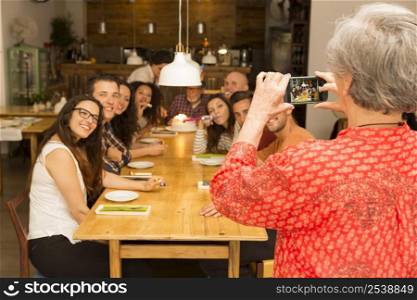 Granny taking a picture of all family celebrating the birthday grandfather