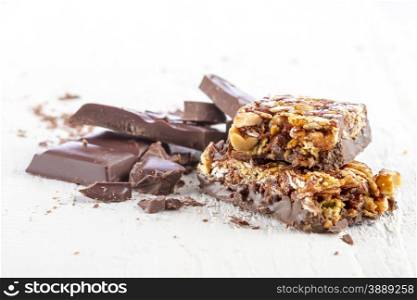 granola bar with chocolate on white wooden background