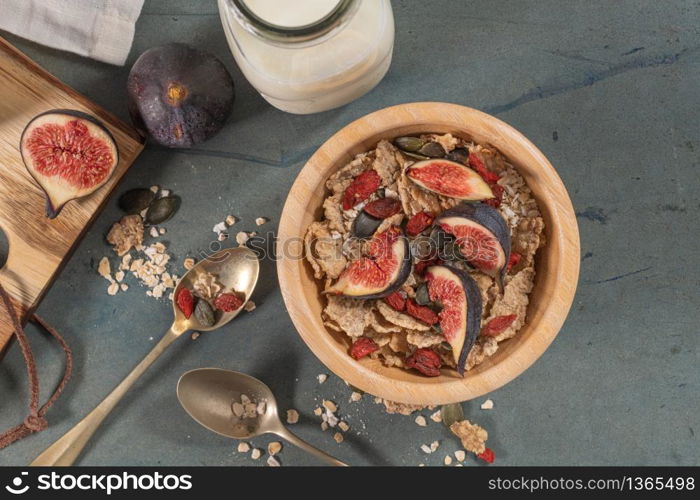 Granola for healthy breakfast. Bowl with granola, milk, fresh fig and dried berries