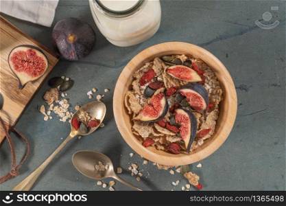 Granola for healthy breakfast. Bowl with granola, milk, fresh fig and dried berries
