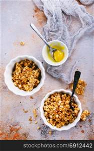 granola with honey in bowl and on a table