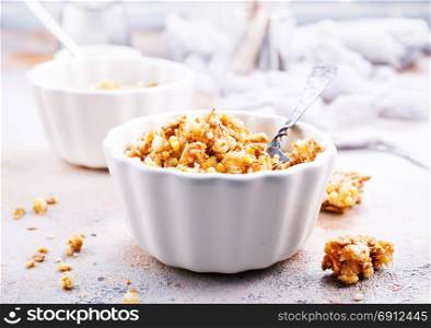 granola with honey in bowl and on a table