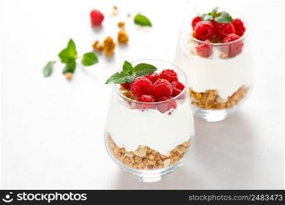 Granola with white plain yogurt and raspberry in a glass