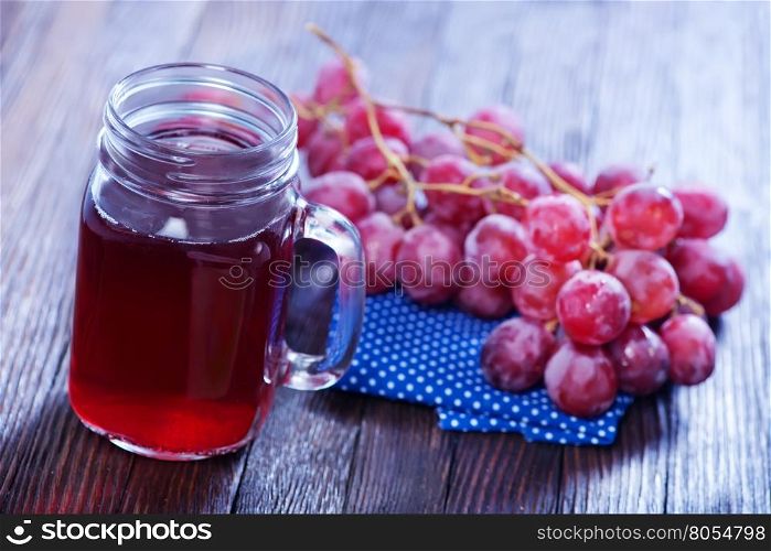 grape juice in glass and on a table