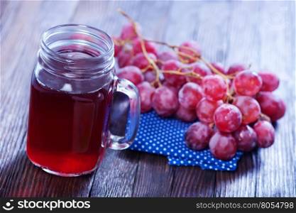 grape juice in glass and on a table