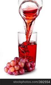 Grape juice pouring from jug into transparent glass and bunch of red grapes isolated on white background. Grape juice pouring from jug into transparent glass