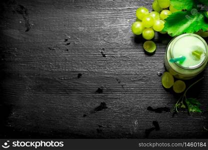 Grape smoothies . On a black wooden background.. Grape fresh smoothies .