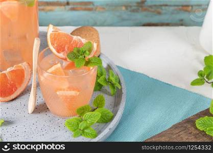 Grapefruit juice with mint in glasses on the table. Refreshing summer cocktail.