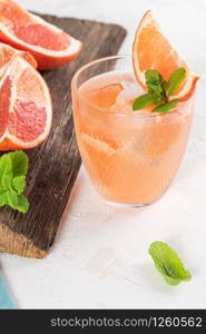 Grapefruit juice with mint in glasses on the table. Refreshing summer cocktail.