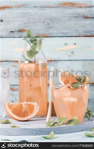 Grapefruit juice with mint in glasses on the table. Refreshing summer cocktail.