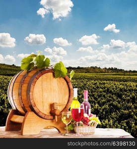 Grapes and bottels of wine near the wooden barrel. Glasses of wine on the table, concept of winery - red and white. concept of winery