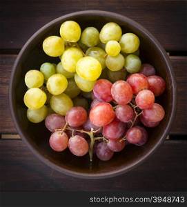 Grapes both white and red in a wooden bowl from overhead