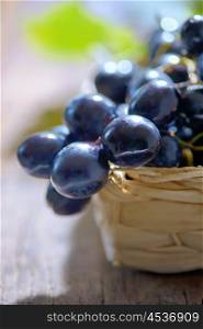 grapes in a basket on wooden background