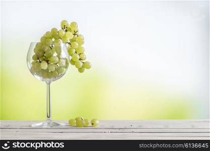 Grapes in a vine glass on a wooden table