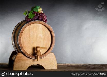 Grapes on wooden barrel with wine and copy space