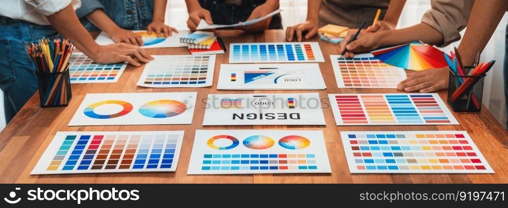 Graphic designer brainstorm logo and graphic art at busy creative studio workshop. Experiment and brainstorm color palette and pattern at workspace table for creative design. Panorama shot. Scrutinize. Graphic designer brainstorming logo and graphic arts at workshop. Scrutinize