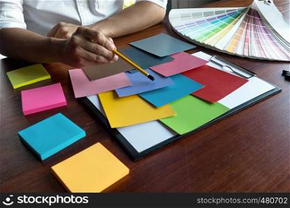 Graphic designer choose colors from the color bands samples for design .Designer graphic creativity working concept.