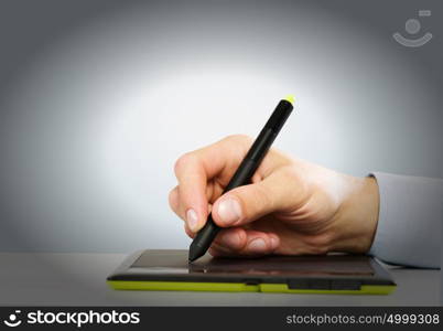 Graphic designer. Close up of human hand using tablet for drawing