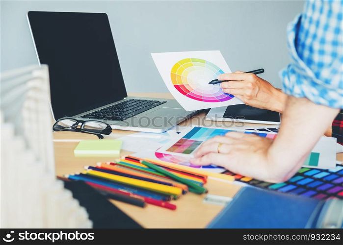 Graphic designer drawing on graphics tablet at workplace
