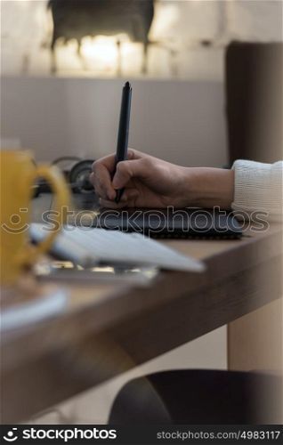 Graphic designer using digital tablet and computer in the office. Hands closeup