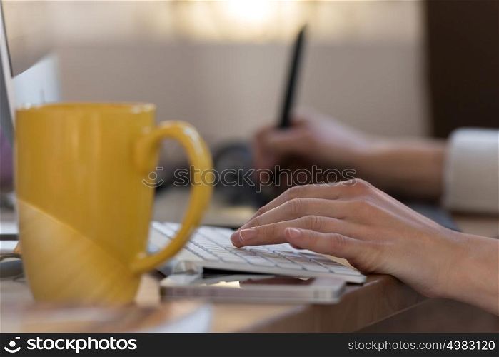 Graphic designer using digital tablet and computer in the office. Hands closeup