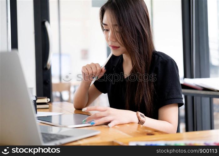 Graphic designer working at her desk in creative studio office.