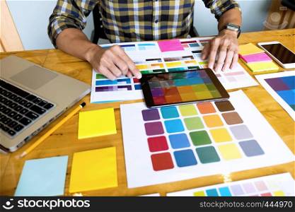 Graphic designers use the tablet to choose colors from the color bar example for design ideas, Creative designs of graphic designers concept.
