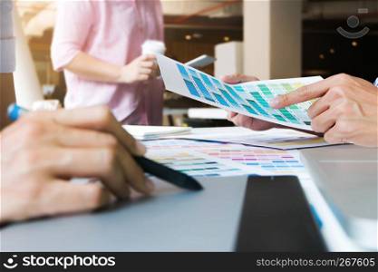 Graphic designers working on color chart at modern office