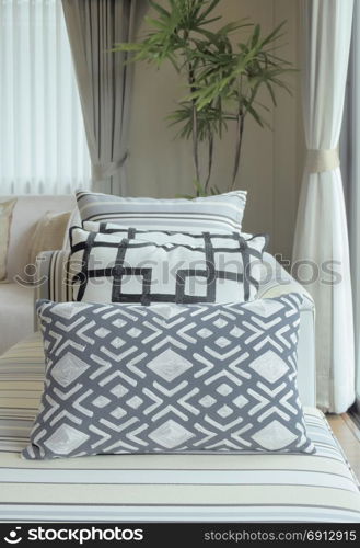 Graphic pattern pillows on striped sofa in modern living room