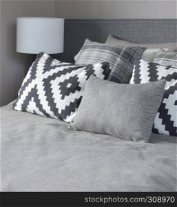 Graphic style and grey shade pillows on classic color bedding set up