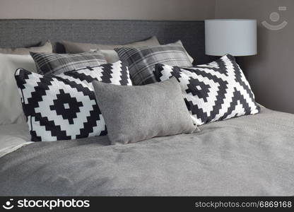 Graphic style and grey shade pillows on classic color bedding set up