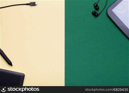 Graphic tablet and digital tablet computer on yellow and green background. Flat lay. MInimal style. Copy space. top view