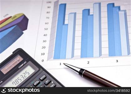 Graphs, calculator and paper statements for finance concept