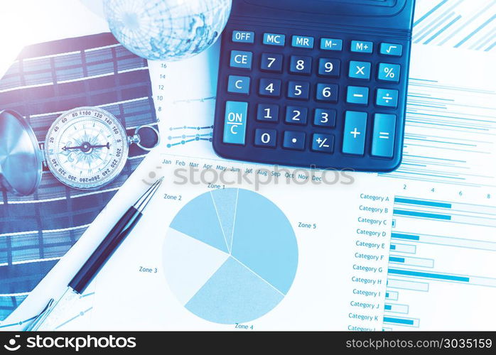 Graphs, charts, calculator, pen, compass on business table. The . Graphs, charts, calculator, pen, compass on business table. The workplace of business people. Blue color tone.