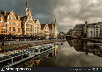 Graslei quay in the historic city center of Ghent, with boats bridge and old flemish buildings, Belgium